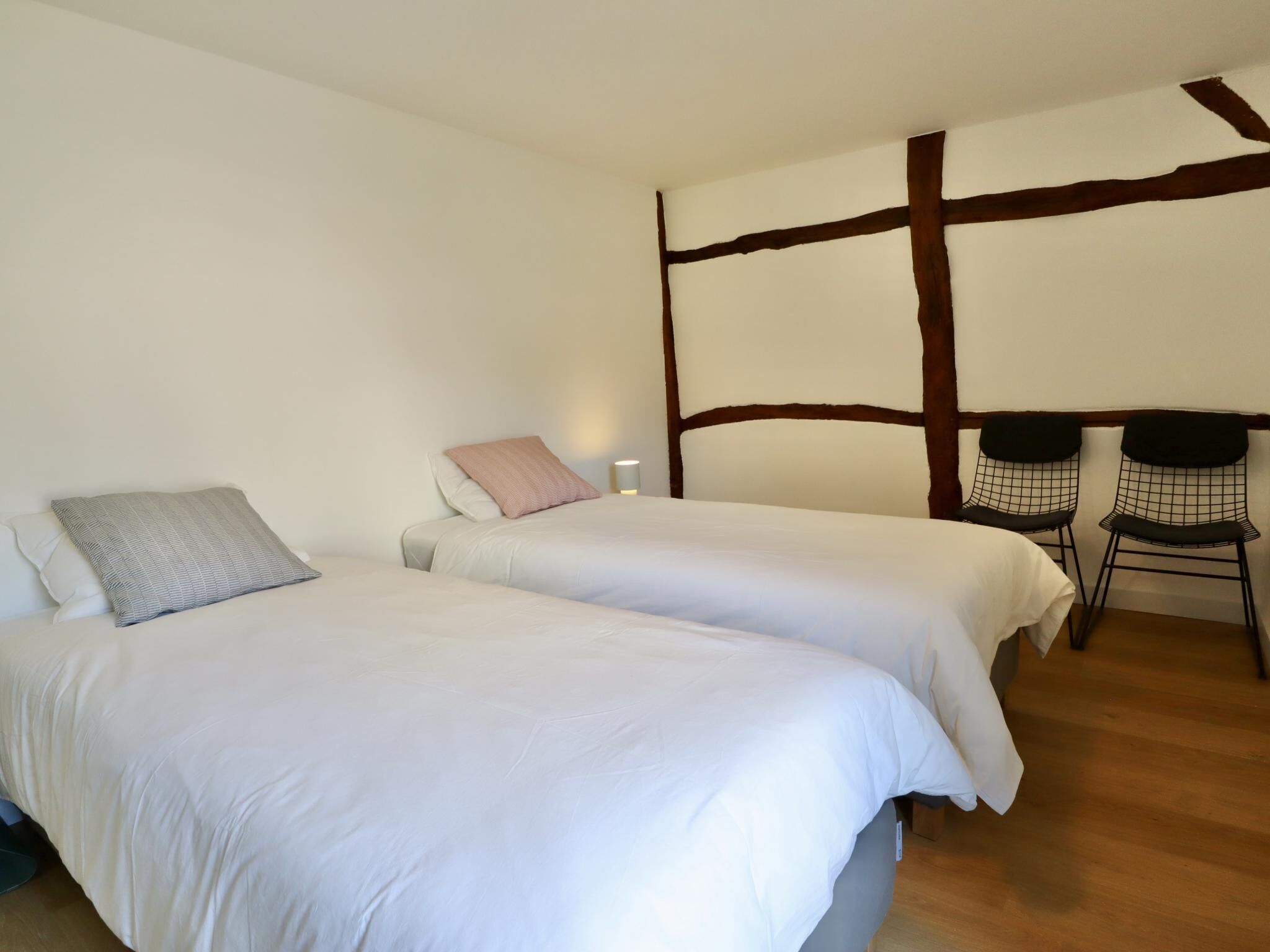 Een kamer met twee bedden, een tafeltje en een stoel.