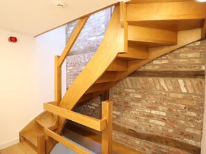 A wooden staircase with a brick wall background. - Intimate village house with a rural location. (Palenge)