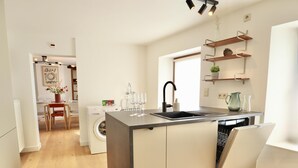 Uma cozinha moderna com máquina de lavar louça embutida, pia e área de jantar com mesa e cadeiras.