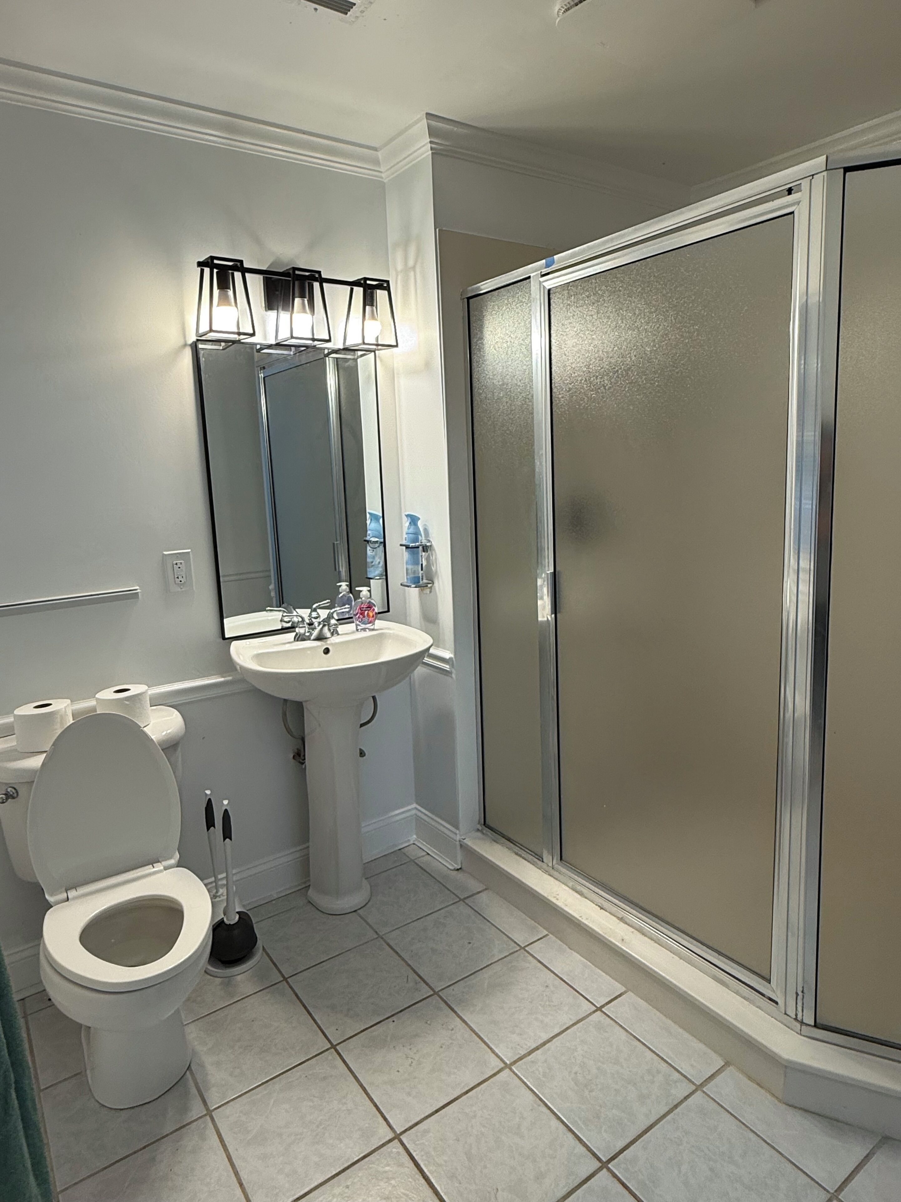 Un baño con inodoro, lavamanos y ducha.