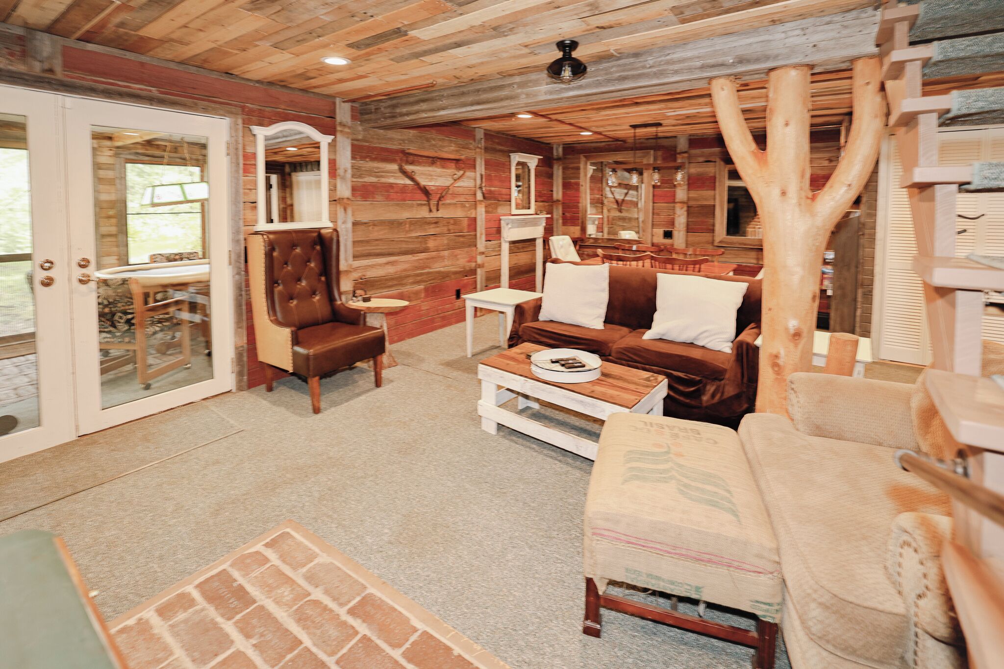 Un intérieur chaleureux avec un plafond en bois, un fauteuil en cuir, un canapé et une table basse.