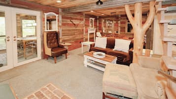 Un intérieur chaleureux avec un plafond en bois, un fauteuil en cuir, un canapé et une table basse.