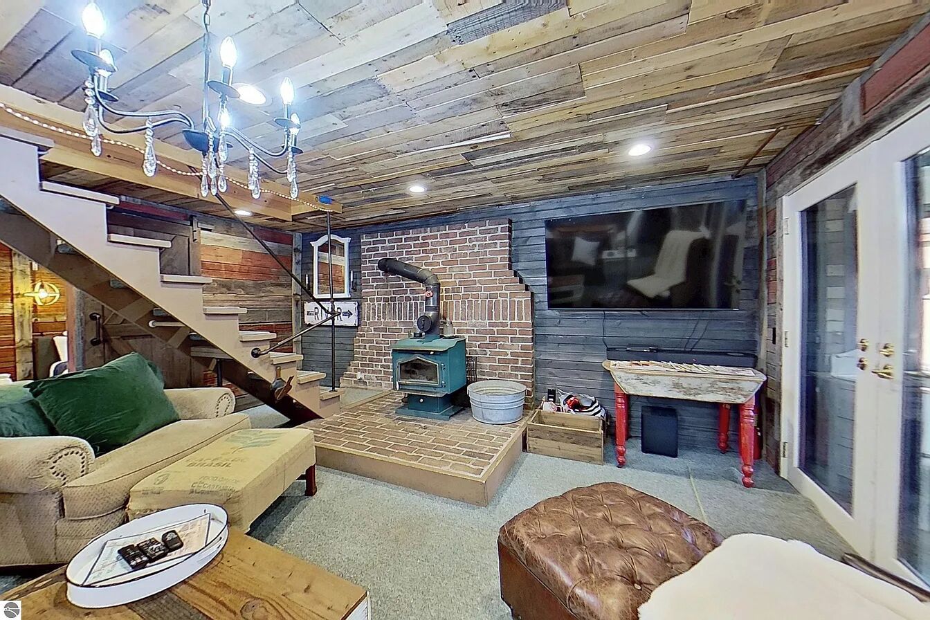 Ein gemütliches Wohnzimmer mit Kamin, Treppe und Essbereich.
