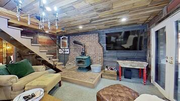 Ein gemütliches Wohnzimmer mit Kamin, Treppe und Essbereich.