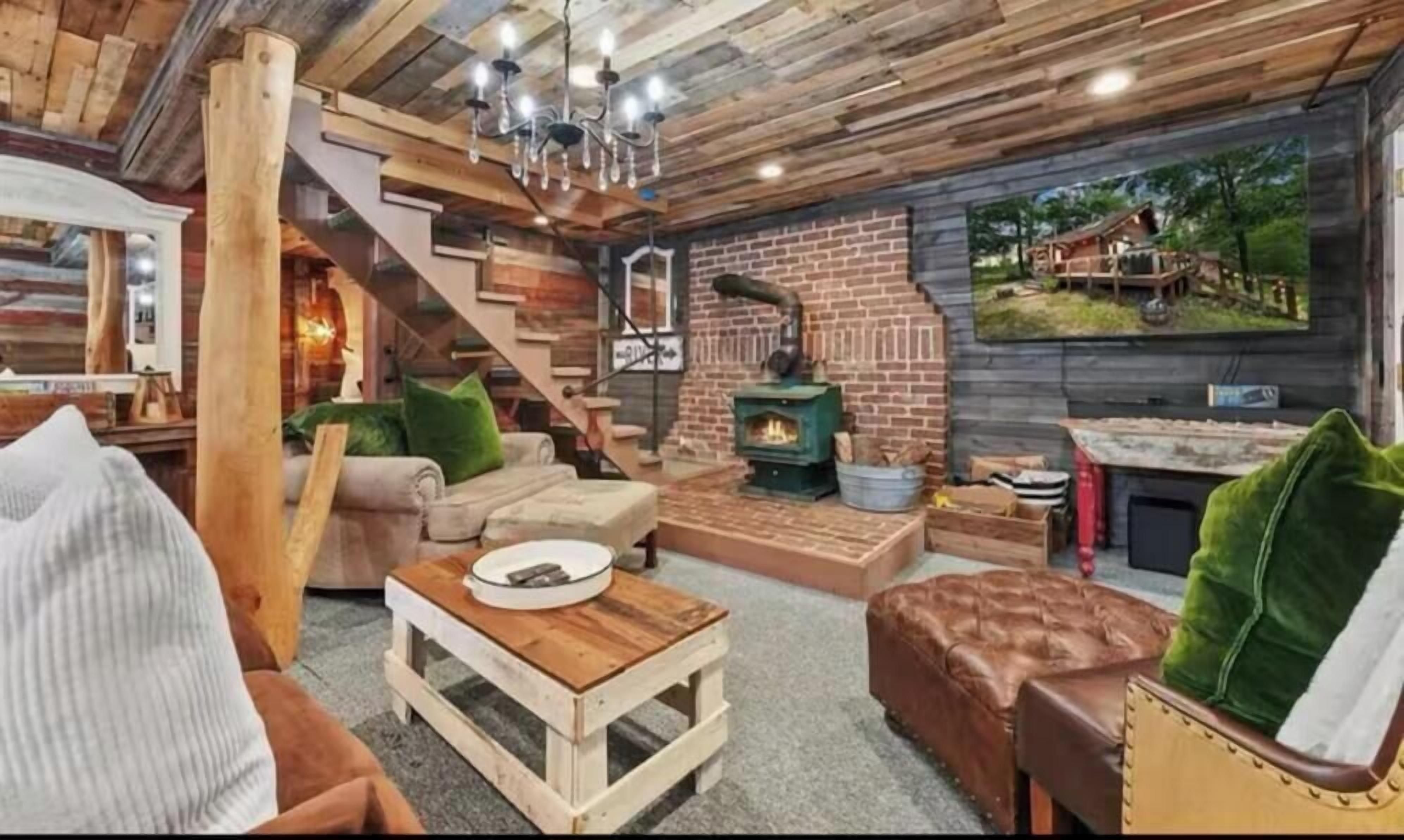 A rustic interior with a fireplace, wooden furniture, and a staircase.