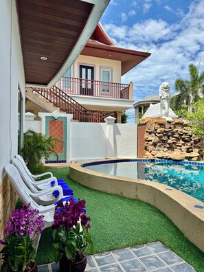 Ein Wohnhaus mit Swimmingpool, Treppe und Balkon.