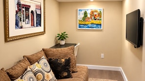 A living room with a sofa, a flat-screen TV mounted on the wall, and two framed artworks. - Cozy 1 BDR close downtown university Ottawa cite collégiale Le CST (Ottawa)