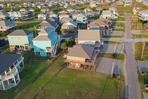 An aerial view of a residential area with houses, some with attached porches and others with front yards. - Beach House Steps to Beach (Bolivar Peninsula)