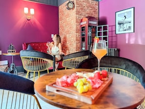 A cozy bar area with a brick wall, a vintage telephone booth, and a table with a fruit platter. - Downtown - Hot Tub, Speakeasy, Grill, Game Room, Fireplace (Ludlow)