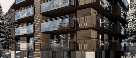 Un immeuble à plusieurs étages, doté de balcons, de grandes fenêtres et situé dans un environnement enneigé.