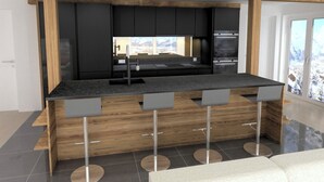 Una cocina moderna con una isla central, armarios negros y electrodomésticos de acero inoxidable.