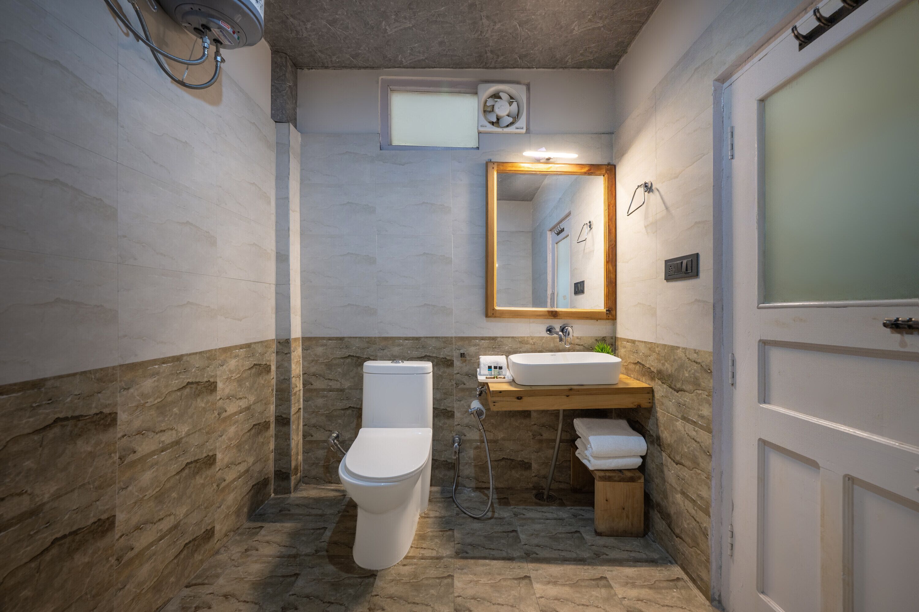 Un baño con inodoro, lavamanos y espejo.