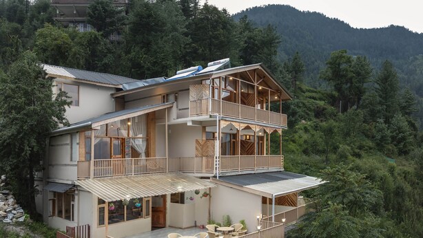 Un edificio de varios pisos con balcones, ventanas amplias y zonas de estar al aire libre.
