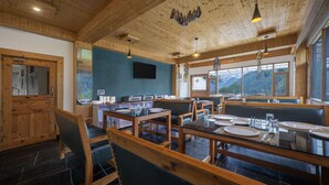 Un restaurante con interiores de madera, varias mesas y sillas.