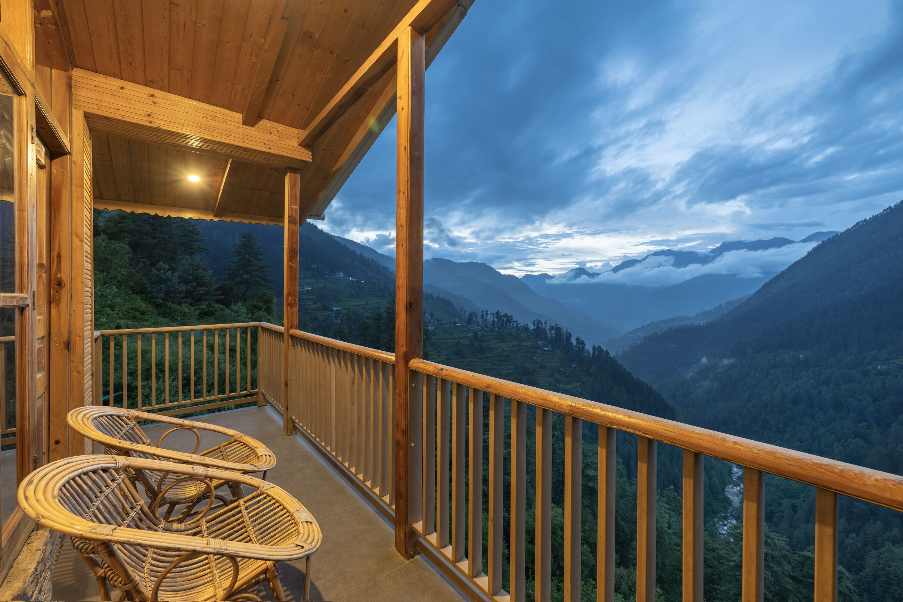 Un balcón de madera con vistas a un paisaje montañoso.