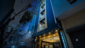 A hotel entrance with a modern design, featuring a glass facade and a sign that reads 'SIGNATURE.' - Hotel Signature Suites (New Delhi)