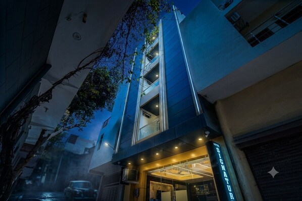 A hotel entrance with a modern design, featuring a glass facade and a sign that reads 'SIGNATURE.' - Hotel Signature Suites (New Delhi)