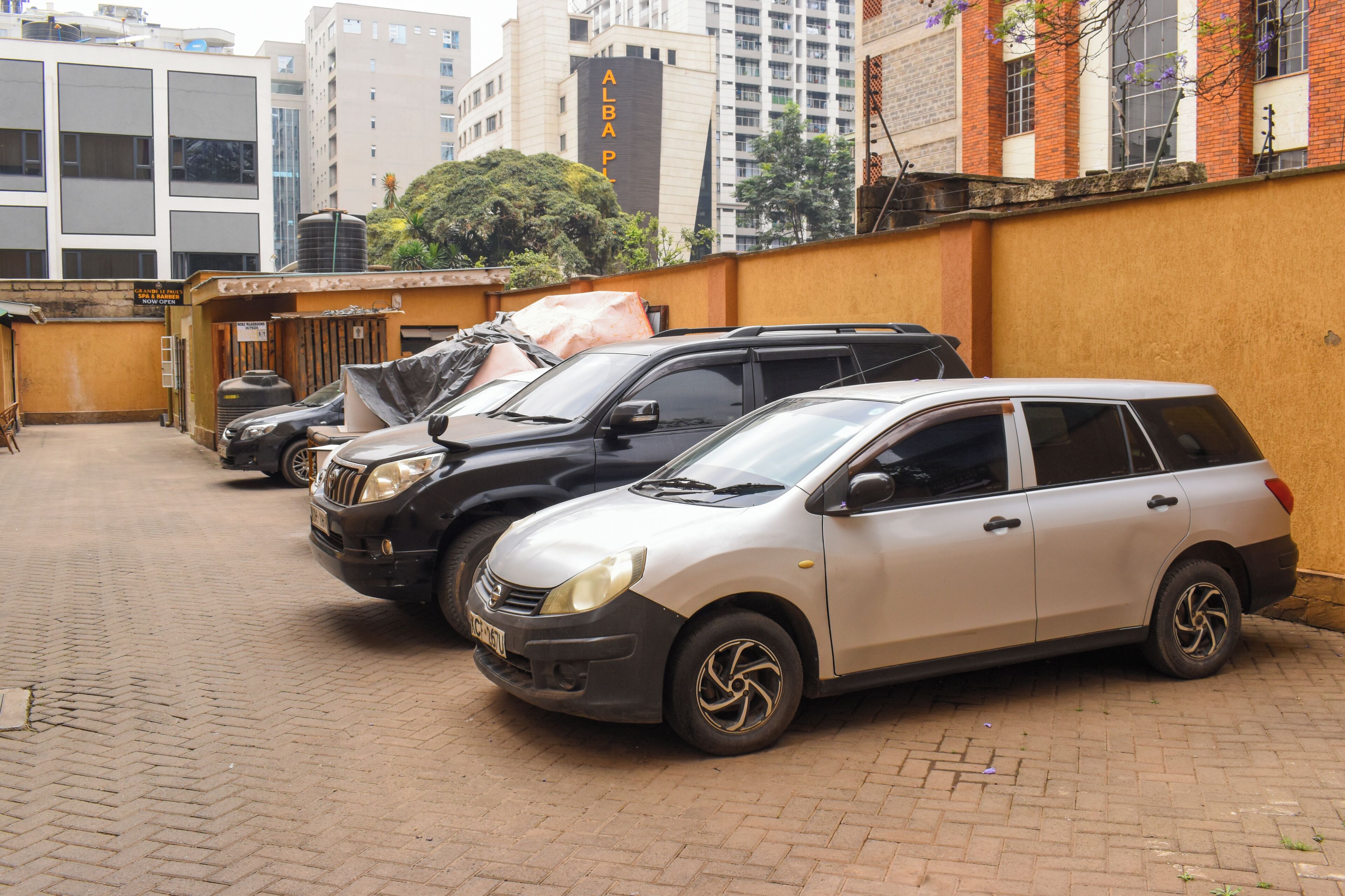 A parking area with several cars parked in a row.