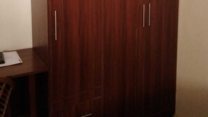 A wardrobe with two doors, a small desk, and a chair. - Jp Resort & Spa (Nairobi)