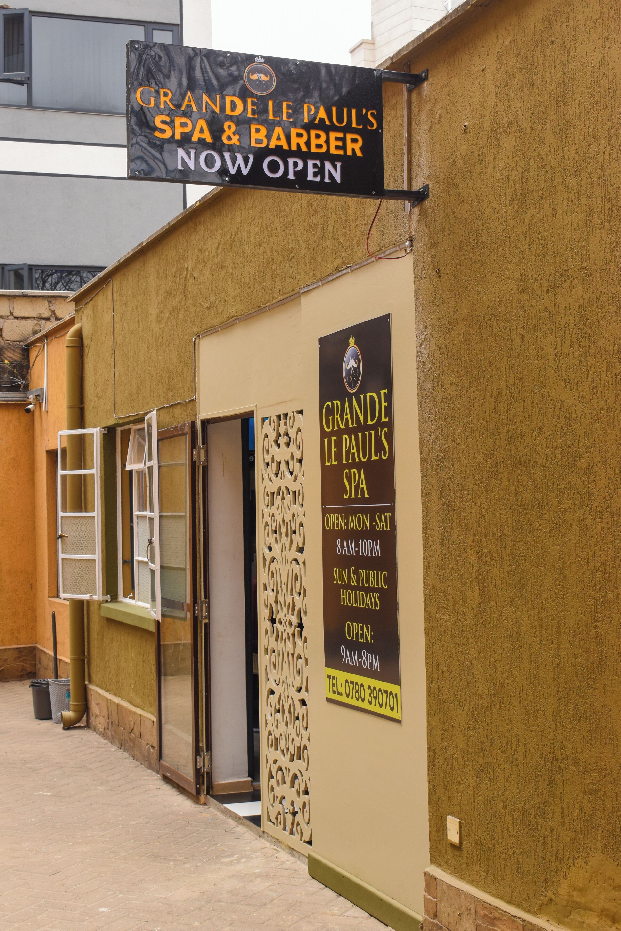 Un spa et un salon de coiffure appelé « GRANDE LE PAUL’S » arborent une enseigne indiquant qu’ils sont ouverts.