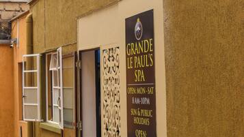 Un spa et un salon de coiffure appelé « GRANDE LE PAUL’S » arborent une enseigne indiquant qu’ils sont ouverts.