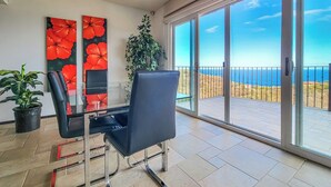 Ein Zimmer mit Glastür und Zugang zu einem Balkon mit Meerblick.