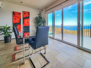 Ein Zimmer mit Glastür und Zugang zu einem Balkon mit Meerblick.