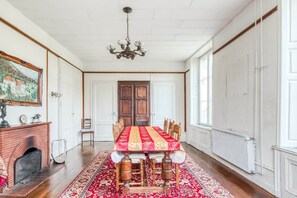 A dining room with a large table, chairs, a fireplace, and a chandelier. - Castle with Private Park & Tennis (Anrosey)