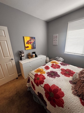 A bedroom with a bed, dresser, and a window with blinds. - Charming 3-bedroom house  in quaint and quiet Reno neighborhood, (Reno)