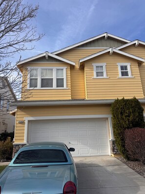 A two-story house with a garage, a light blue car parked in front, and a number '2135' on the house. - Charming 3-bedroom house  in quaint and quiet Reno neighborhood, (Reno)