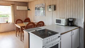 A compact kitchen with a built-in stove, microwave, and coffee maker. - 5 Person Holiday Home in Hadsund (Hadsund)