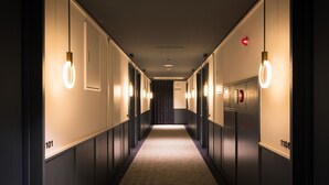 A hotel hallway with a carpeted floor, doors numbered 101 and 1108, and wall-mounted light fixtures. - R Hotel Nagoya Station (Nagoya)