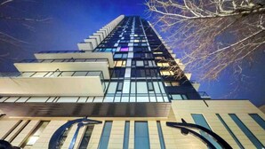 Un moderno edificio de gran altura con fachada de vidrio y una entrada destacada.