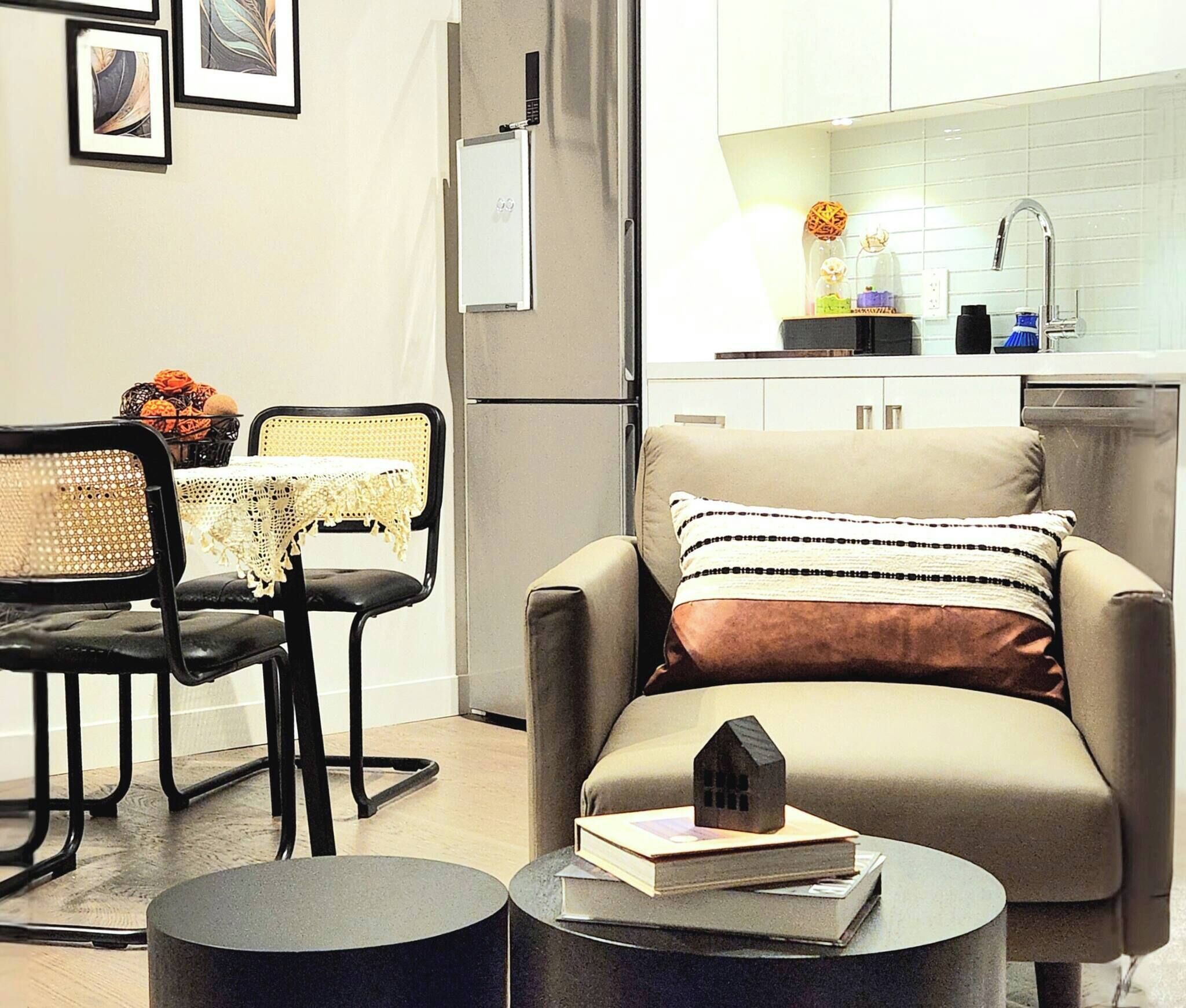 Una sala de estar moderna con un sofá, un comedor con una mesa y sillas, y una cocina con un lavamanos y armarios.