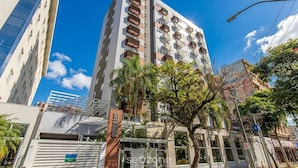 A multi-story building with balconies, a gated entrance, and a clear blue sky. - Studio in Condo w/ Pool in POA Pue0308 (Porto Alegre)
