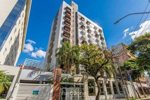 A multi-story building with balconies, a gated entrance, and a clear blue sky. - Studio in Condo w/ Pool in POA Pue0308 (Porto Alegre)