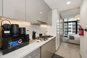 A modern kitchen with a digital control panel, a coffee machine, and a gas stove. - Bloomfields Studio in Azizi Riviera 34 (Dubai)