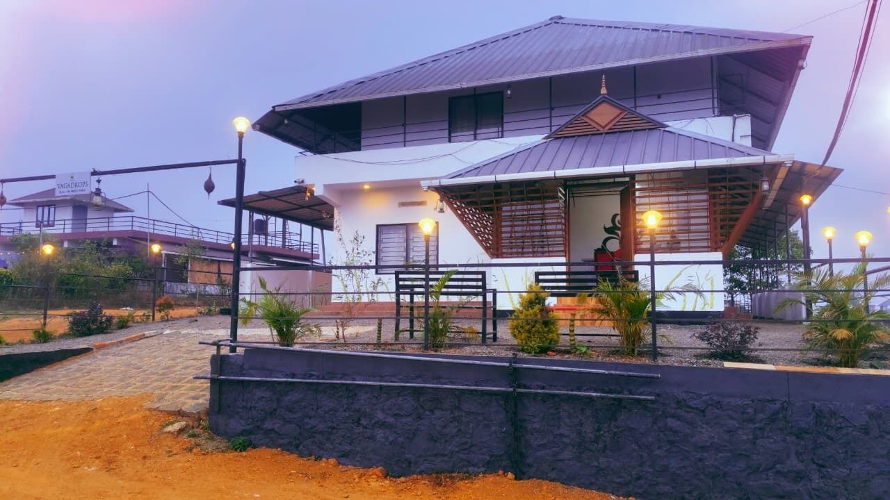 A two-story building with a sloped roof, a covered porch, and a staircase leading to the upper floor.