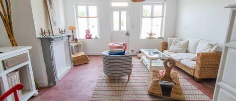 Un salón espacioso con chimenea, un conjunto de sofás, una mesa de centro y un amplio ventanal que proporciona luz natural.