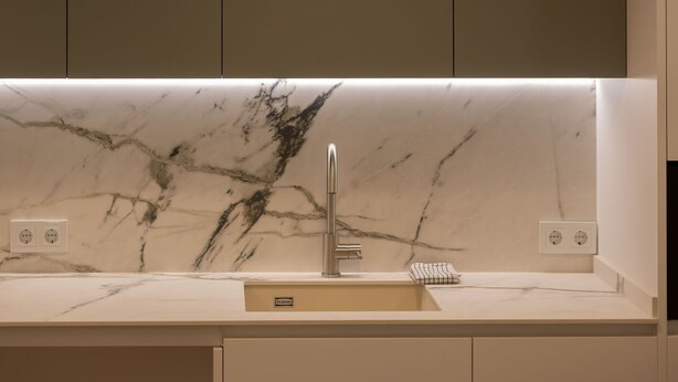 A modern kitchen with a marble countertop, a single faucet, and a pendant light above the sink. - Brand-new apartment with an accessible bathroom and kitchen. Perfect for families! (Nerja)