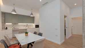 A modern kitchen with marble countertops, pendant lighting, and a dining area with a marble table and chairs. - Brand-new apartment with an accessible bathroom and kitchen. Perfect for families! (Nerja)