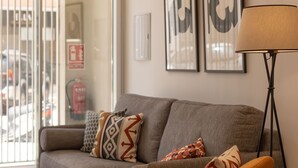 A modern living room with a grey sofa, orange armchair, and a floor lamp. - Brand-new apartment with an accessible bathroom and kitchen. Perfect for families! (Nerja)