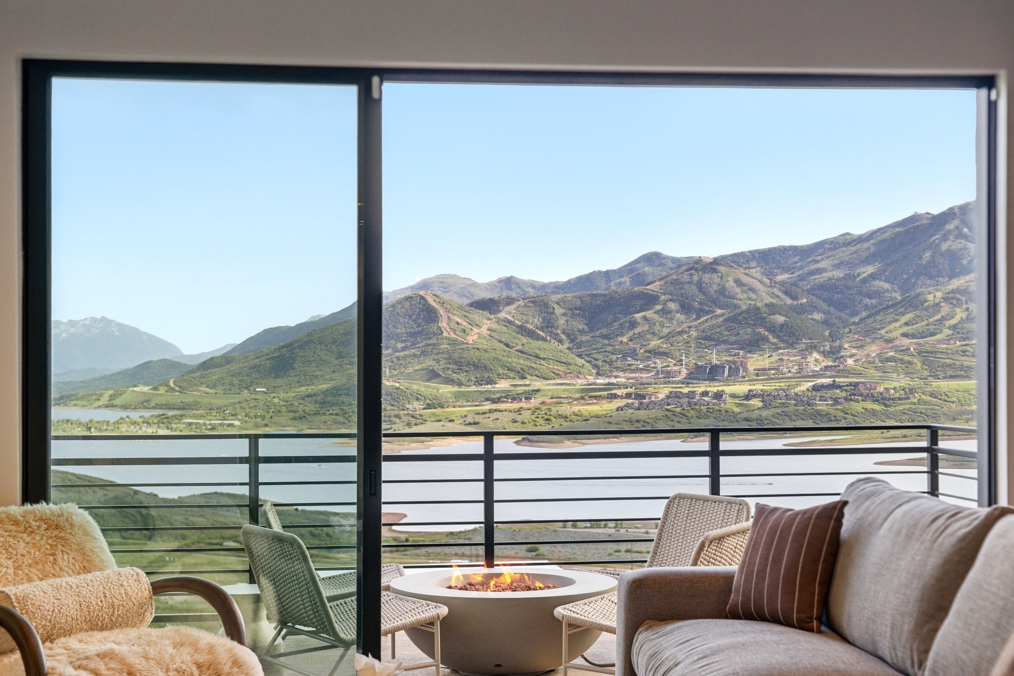 Un balcón con chimenea, asientos y vistas panorámicas de la montaña.
