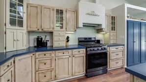 Una cocina con armarios de madera, una estufa y un microondas.