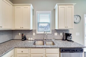 A kitchen with white cabinets, a granite countertop, a stainless steel sink, a coffee maker, and a dishwasher. - Fenced Yard! Monthly Stay, 4 Mi to Dtwn Clayton (Clayton)