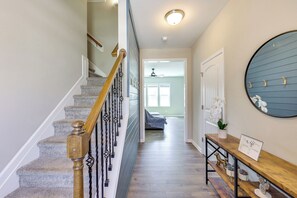 Un escalier avec une rampe en bois et un luminaire fixé au mur au-dessus.