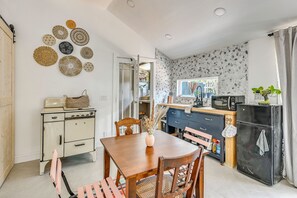 A compact kitchen with a vintage stove, modern microwave, and a dining area with a wooden table and chairs. - Grill & Porch! Extended Escape, 2 Mi to Ybor City (Tampa)
