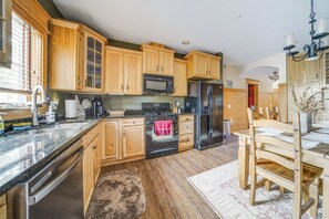 A kitchen with wooden cabinets, a stainless steel refrigerator, a microwave, and a stove. - Walk to Conneaut Lake Park Resort! Quiet Home (Conneaut Lake)