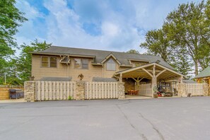 A two-story house with a covered porch, a stone wall, and a wooden fence. - Walk to Conneaut Lake Park Resort! Quiet Home (Conneaut Lake)