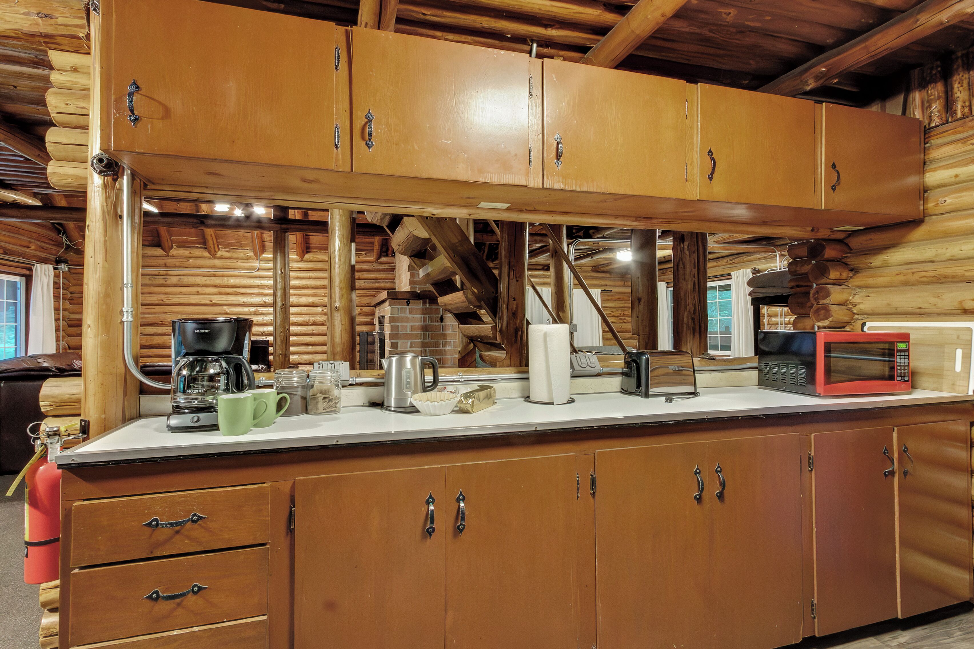 Una cucina in legno con piano di lavoro, pensili e una macchina per il caffè.